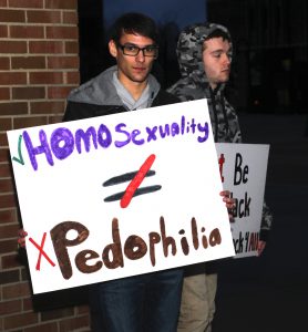 Kasey Willener and Brian Tompson hold signs outside the KIVA on Feb. 8, 2016